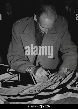 Berühmte Flagge. Feldmarschall Viscount Montgomery Autogramme einer Nazi-Flagge, die gestern bei seinem Besuch im Australian war Museum in Canberra von einer deutschen Panzerbesatzung in Alamein gefangen genommen wurde. „Sie haben die Flagge, die Rommel in Kairo hätte fliegen sollen“, sagte er. 07. Juli 1947. Stockfoto
