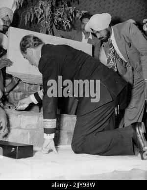 Mountbatten legt Grundstein - der frühe Mountbatten, Generalgouverneur von Indien, hockt auf beiden Knien, um den Zement mit einer silbernen Kelle für einen Grundstein an der Delhi University, Indien, im März 7, zu nivelieren. Der Gouverneur verlieh Pandit Nehru, dem indischen Premierminister, früher den Ehrendoktortitel der Briefe und wurde später selbst mit dem Grad der Doktorwissenschaft ausgestattet. 13. März 1948. (Foto von Associated Press Photo). Stockfoto