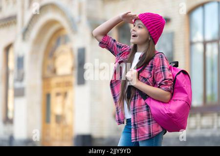 Happy teen Mädchen zurück zur Schule Blick in die Ferne halten Hand über den Augen im Freien, kopieren Raum Stockfoto