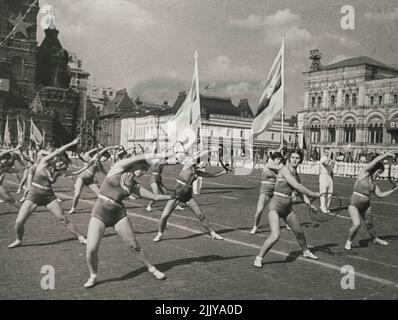 Der XXIII. Internationale Jugendtag in Moskau -- Physikkulturisten des Sportvereins „Burevestnik“ (Sturmsturmsturmsturmsturmläufer), die Turnübungen mit Reifen machen, während sie an der Tribüne auf dem Roten Platz vorbeikommen. Am 12. September 1937 feierte die Jugend der sowjetischen Hauptstadt triumphierend den XXIII. Internationalen Jugendtag. Eine Million junger Patrioten, einer Generation freier, junger Baumeister des Sozialismus, voller Optimismus und sicher von morgen, demonstrierten ihre Stärke und Macht, ihre Hingabe an die Partei Lenins-Stalins und die Sowjetregierung. 1. September 1937. (Foto von Soyuzphoto). Stockfoto