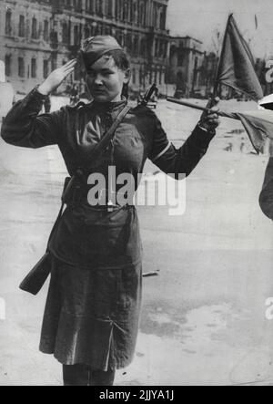 Russisches Mädchen am Brandenburger Tor - Berlin -- Feodora Bondarenko, eine russische Polizistin, die den Verkehr durch das Brandenburger Tor lenkt. Berlin, sie ist 22 Jahre alt, und mit einem Gewehr über den Schultern steht Feodora auf einem kleinen rot-sternigen Dais und schwenkt zwei kleine rote und gelbe Flaggen mit der gerade rückenden Effizienz eines britischen Marine-Rating-Semaphoring-Schiffe. 6. Juli 1945. (Foto von Planet). Stockfoto