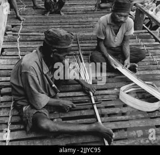 . Zwar haben die Sakai in Malaya und die IBAN-Stämme von Borneo ihre Häuser vom Boden abgesteckt, aber sie sind wieder anders. In der Stadt Brunei sind die Malaien noch besser geworden. In der Stadt Brunei sind die Malaien um eins besser gegangen, sie haben ihre Stadt in einem Fluss gebaut. Zehntausend Männer, Frauen und Kinder werden geboren, leben und sterben, essen und schlafen über dem Wasser des Brunei-Flusses. Viele haben in ihrem Leben selten einen Fuß auf echtes trockenes Land gesetzt. Neben der Fischerei führen die Malays des Flusses Kampong eine Reihe von Handwerken durch und Brunei Silber hat eine eigene Auszeichnung. 01.Mai 1950. (Foto von British Official Photograph). Stockfoto