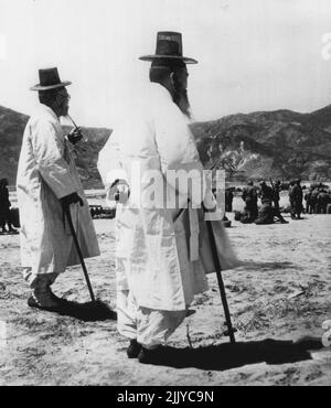 The Old Sains the New – zwei Patriarchen des alten Korea, die erlebt haben, wie der Krieg ihr unruhigen Land verwüstet hat, beobachten mit scheinbarer Lässigkeit, wie die US First Division irgendwo in Korea Marines mit ihren Werkzeugen für den modernen Krieg führt. 27. April 1951. (Foto von AP Wirephoto). Stockfoto
