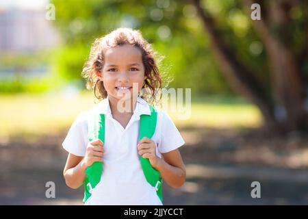 Die Kinder gehen zurück zur Schule. Interrassische Gruppe von Kindern unterschiedlichen Alters laufen und jubeln am ersten Tag des neuen akademischen Jahres. Beginn der Schulferien. Stockfoto