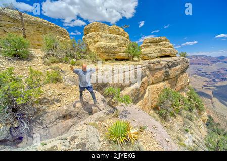 Ein Wanderer, der über eine Spalte entlang einer Klippe westlich von Twin Views springt, blickt auf den Grand Canyon Arizona. Stockfoto