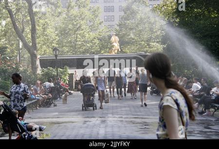 New York, USA. 28.. Juli 2022. (NEU) die Leute nutzen ein gebrochenes Rohr im Central Park, indem sie mit dem Wasser nass werden. 28. Juli 2022, New York, USA: Aufgrund der Hitze und des heißen Wetters, das bis zu 87Ã‚Â C erreicht hat, werden die Menschen gesehen, wie sie am Central Park in der Nähe von 30Ã‚Â zooÃ¢â‚¬â„¢ein gebrochenes Rohr ausnutzen, spielen und sich mit dem Wasser nass machen. Das Leck verursacht jedoch Probleme und Schwierigkeiten für einige, mit Babytrollern vorbei zu kommen. (Bild: © Niyi Fote/TheNEWS2 via ZUMA Press Wire) Stockfoto