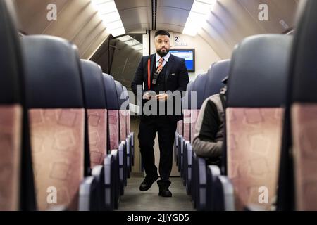 2022-07-28 22:21:12 UTRECHT - Ein Leiter der NS prüft Tickets in einem Zugabteil auf der Strecke zwischen Utrecht und Rotterdam. ANP RAMON VAN FLYMEN niederlande Out - belgien Out Stockfoto