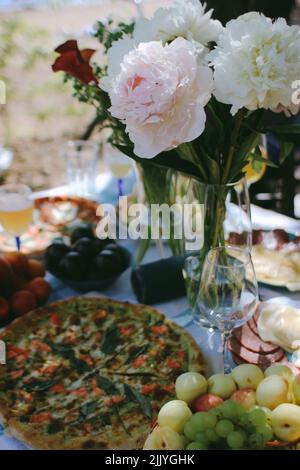 Picknick mit Blumen und Pizza Stockfoto
