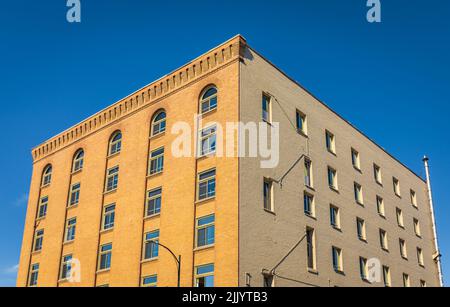 Moderne Architektur aus Backsteingebäude mit Glasfenstern auf der städtischen Straße einer Stadt. Fassade des historischen Hauses in Victoria BC. Architekturkonzept, Stockfoto