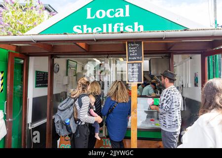 Kunden, die frische Meeresfrüchte und Schalentiere im Hafen von Oban kaufen, Muscheln, Krabben, Hummer, die alle verkauft werden, und Muscheln, die in Knoblauch, Oban, Highlands, Schottland gekocht werden, Stockfoto