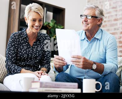 Es ist wichtig, den Vertrag zu lesen. Ein älterer männlicher makler geht durch Papierkram mit einem Kunden. Stockfoto