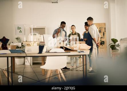 Mode, Design und Stil mit einem jungen und vielfältigen professionellen Team, das in einer kreativen Textil-Werkstatt arbeitet. Gruppe von Arbeitskollegen schaffen trendy Stockfoto