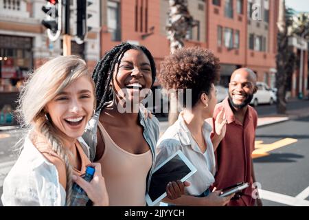 Eine Gruppe verschiedener Studenten, die an einem sonnigen Sommertag Spaß im Freien in der Stadt haben. Porträt von jungen Menschen oder Freunden, die zusammen lachen und lächeln Stockfoto