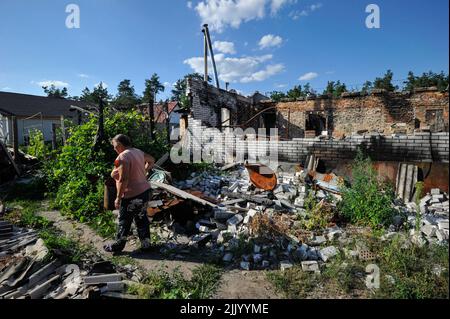 Moshchun, Ukraine. 28.. Juli 2022. Eine Frau kommt an einem zerstörten Wohngebäude vorbei, das durch den Beschuss der russischen Armee im Dorf Moschtschun in der Nähe der ukrainischen Hauptstadt Kiew beschädigt wurde. Russland marschierte am 24. Februar 2022 in die Ukraine ein und löste damit den größten militärischen Angriff in Europa seit dem Zweiten Weltkrieg aus Kredit: SOPA Images Limited/Alamy Live Nachrichten Stockfoto