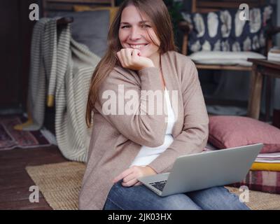 Emotionale Frau mittleren Alters studiert zu Hause mit Laptop. Freut sich über gute Nachrichten, Frau liest E-Mail oder Social-Media-Nachricht, gewinnt Online-Lotterie, großes Shopping-Angebot, sitzt auf Veranda zu Hause Stockfoto