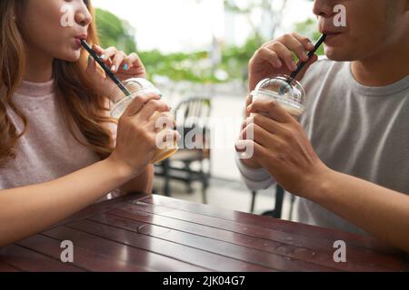 Junges Paar genießt Cocktails im Café im Freien Stockfoto