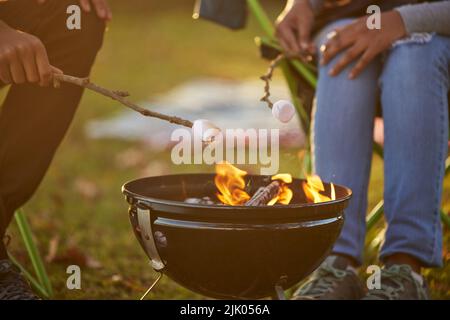 Ich fühle mich sehr peckisch. Ein Paar, das während des Campens Marschmelzchen röstet. Stockfoto