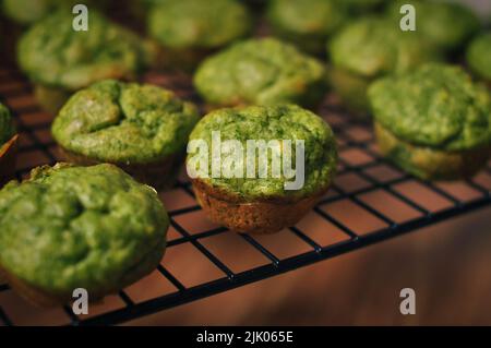 Fertige kleine grüne Muffins mit Spinat auf einem Backblech Stockfoto