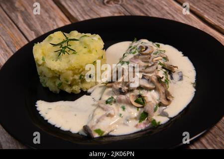 Rezept für das Filet der Seebrasse in Weißweinsauce mit Kartoffelpüree und Pilzen Stockfoto