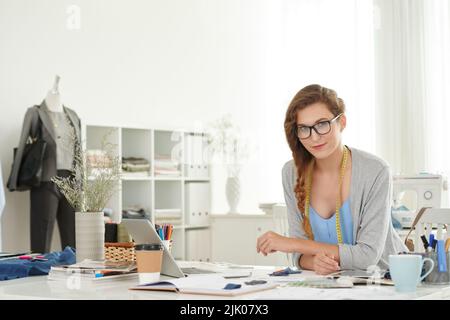 Porträt einer lächelnden Schneiderin an ihrem Arbeitsplatz Stockfoto