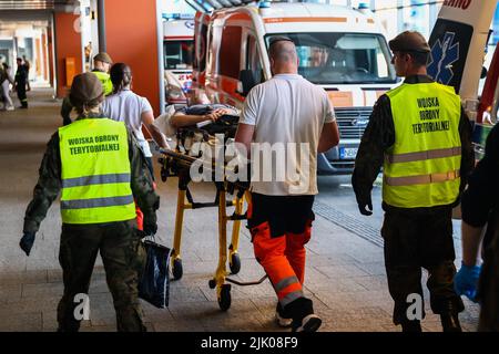 Krakau, Polen. 28.. Juli 2022. Am 28. Juli 2022 trägt polnisches medizinisches Personal einen verwundeten ukrainischen Soldaten (Gesicht verschwommen) auf einer Bahre am Hauptbahnhof in Krakau, Polen. Fünfzehn verwundete Soldaten während der russischen Invasion der Ukraine wurden von der Ukraine nach Krakau mit einem humanitären Spezialzug transportiert und werden zur weiteren Behandlung in Krankenhäuser in der Woiwodschaft Kleinpolen geschickt. (Bild: © Beata Zawrzel/ZUMA Press Wire) Stockfoto