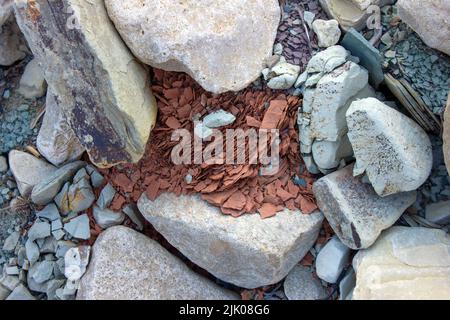 Ein Stein zerfiel am Fluss in kleine Stücke. Stockfoto