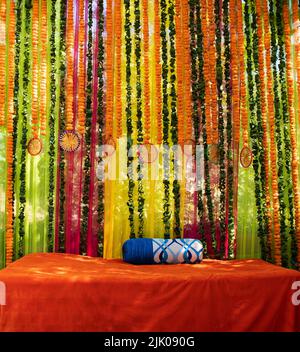 Traditionelle indische Hochzeitszeremonie im Freien Dekoration. Dekoration von bunten Blumengirlanden, Blumen, Rosen. Trauung des Bräutigams vor der Hochzeit im Freien. Stockfoto