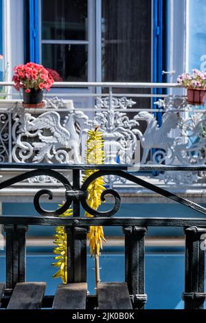 Griechisches Haus mit roter Pflanze und gelben Blumen Stockfoto