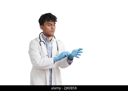 Junger peruanischer Arzt mit blauen Handschuhen, isoliert. Stockfoto