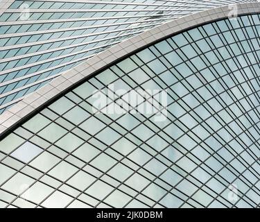 Fragment eines modernen Bürogebäudes. Abstrakter geometrischer Hintergrund. Teil der Fassade eines Wolkenkratzers mit Glasfenstern. Stockfoto