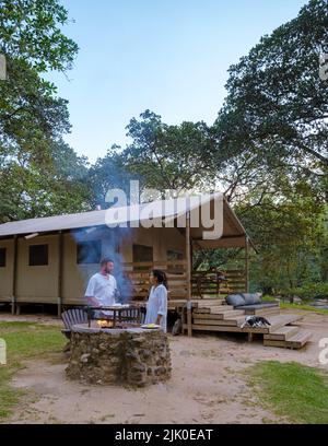 Budget Safari Zelt in Südafrika für Familienurlaub in der Natur, Safari Zeltlager in grüner Wald Busch Natur. Asiatische Frauen und europäische Männer campen Stockfoto
