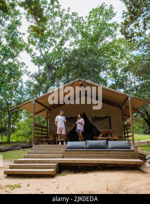 Budget Safari Zelt in Südafrika für Familienurlaub in der Natur, Safari Zeltlager in grüner Wald Busch Natur. Asiatische Frauen und europäische Männer campen Stockfoto