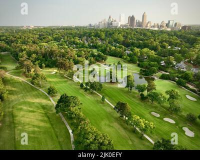 Eine Luftaufnahme des Grünfeldes, umgeben von dichten Bäumen im Hintergrund von Gebäuden in Atlanta Stockfoto