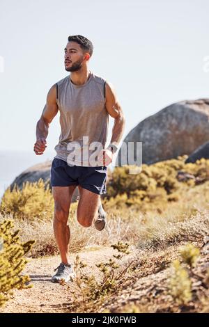 Grenzen müssen verschoben werden. Ganzkörperaufnahme eines hübschen jungen Mannes, der allein im Freien läuft. Stockfoto