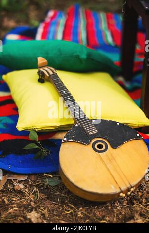 Vintage-Banjo aus Holz liegt auf hellen Kissen. Stockfoto