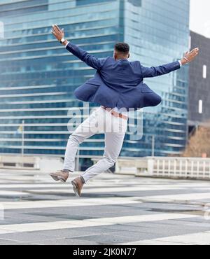 Glück liegt in der Freude des Erfolgs. Ein junger Geschäftsmann feiert draußen. Stockfoto