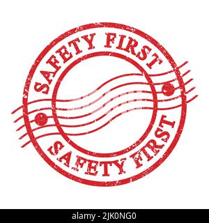 SICHERHEIT ZUERST, Text auf rotem grungigen Briefmarke geschrieben. Stockfoto