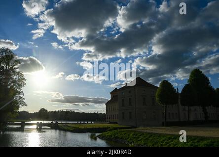 27. Juli 2022, Brandenburg, Rheinsberg: Schloss Rheinsberg und Grienericksee im Hintergrund. Vorbei an Wolkenfeldern und gelegentlich auch Sonne bestimmen das Wetter am Wochenende in Berlin und Brandenburg. Am Freitag wird es weitgehend trocken bleiben, wie der Deutsche Wetterdienst in Potsdam mitteilte. Die Temperaturen steigen auf 25 bis 29 Grad. In der Nacht zum Samstag sind insbesondere an der Grenze zu Sachsen mit Schauern und Gewittern zu rechnen. Foto: Jens Kalaene/dpa Stockfoto