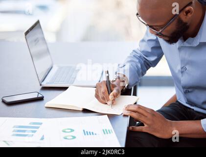 Es braucht richtige Planung, um etwas zu einem Erfolg zu machen. Ein Geschäftsmann, der sich Notizen macht, während er an seinem Schreibtisch sitzt. Stockfoto