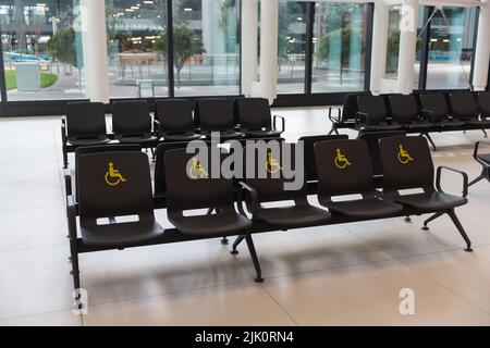 Reservierte Sitzplätze und Schilder für Menschen mit Behinderungen am Flughafen Istanbul, Turkiye Stockfoto