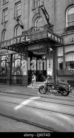 Eine Vertikale eines Fahrrads, das im Wynns Hotel in Dublin, Irland, geparkt wurde, wurde in Graustufen gedreht Stockfoto