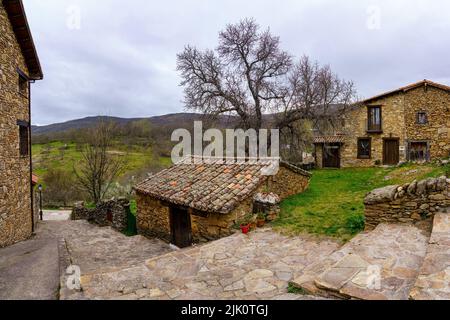 Kleines Steinhaus in einer Altstadt mit typischen Steinhäusern und Treppen in der Gasse. Horcajuelo Madrid. Spanien. Stockfoto