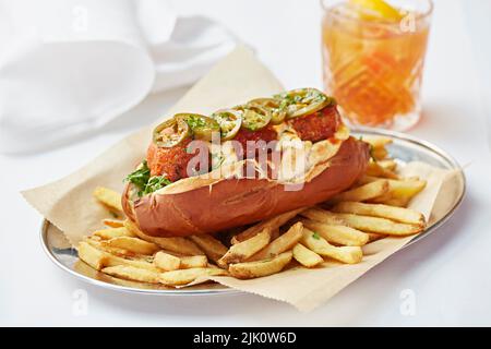 Würziges Fleischbällchen-Sub-Sandwich serviert mit Pommes Frites Stockfoto