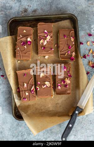 Millionaire'S Shortbread mit Karamell, Schokolade und getrockneten Rosenblättern Stockfoto