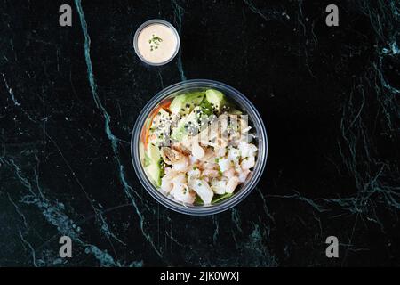 Eine gesunde Schüssel mit Avocado, Meeresfrüchten und Quinoa zum Mitnehmen Stockfoto