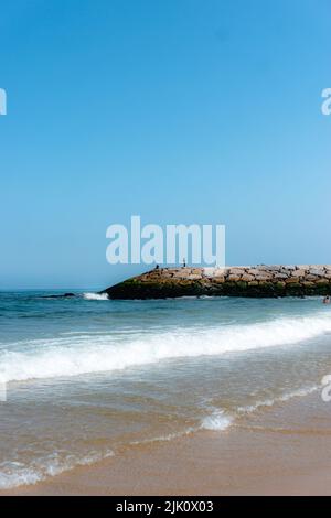 Eine vertikale Aufnahme von Fischern am Strand Vieira de Leiria in Portugal an einem sonnigen Tag Stockfoto