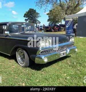 Chascomus, Argentinien - 9. Apr 2022: Alter schwarzer Ford Fairlane 500 1959 auf dem Land. Natur, Gras, Bäume. Oldtimer-Show. Copyspace Stockfoto