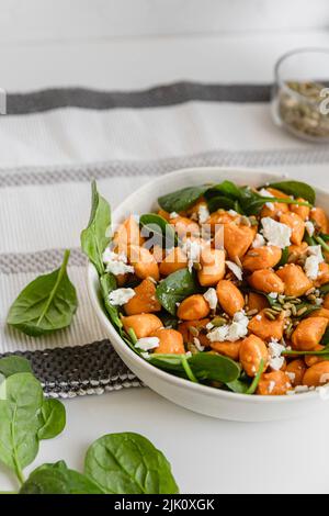 Kürbis-Gnocchi mit Feta-Salat und Baby-Spinatblättern Stockfoto