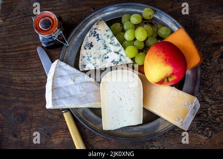 Käseplatte mit Trauben und Apfel Stockfoto