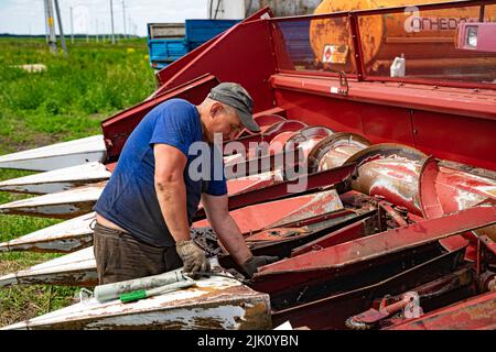 Kasan, Russland. 2022, Juni 12. Ein Mann, der einen Mähdrescher repariert. Moderne Landmaschinen. Konzept Thema Reparatur Stockfoto